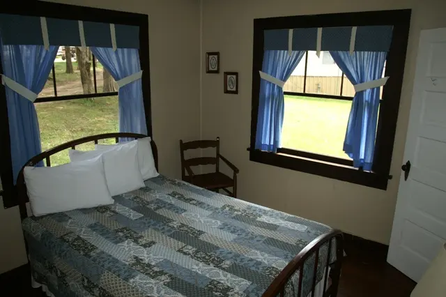 blue bed with curtains and large windows