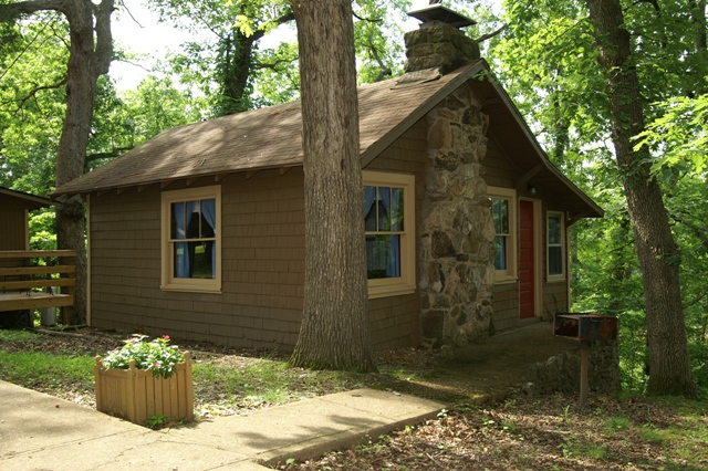 log cabin with trees and a flower planter box