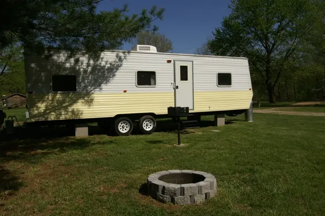 RV with yellow stripe and stone well