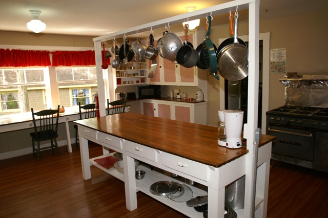 kitchen with hanging pots and pans rack in white