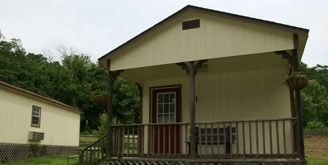 A small house with a porch and a railing.