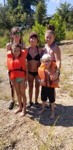 family in life jackets and bathing suits