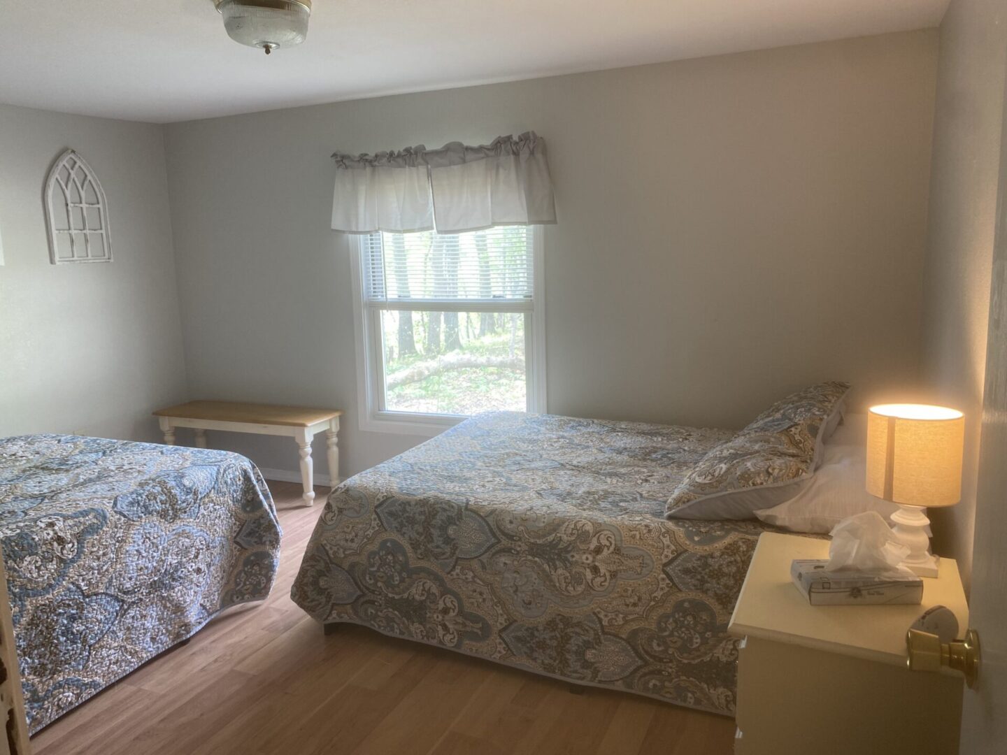 A bedroom with two beds and a window.