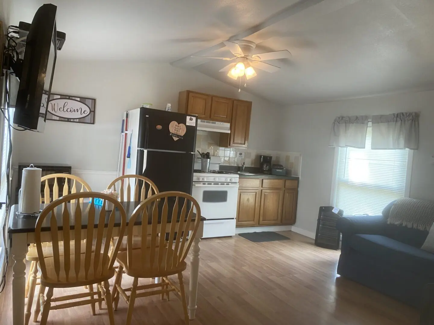 A kitchen with a refrigerator, microwave and oven.