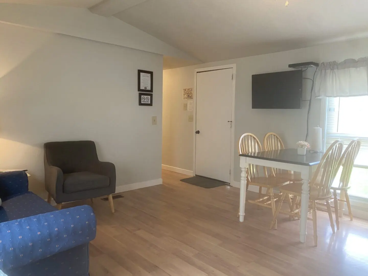 A living room with a couch, chair and television.