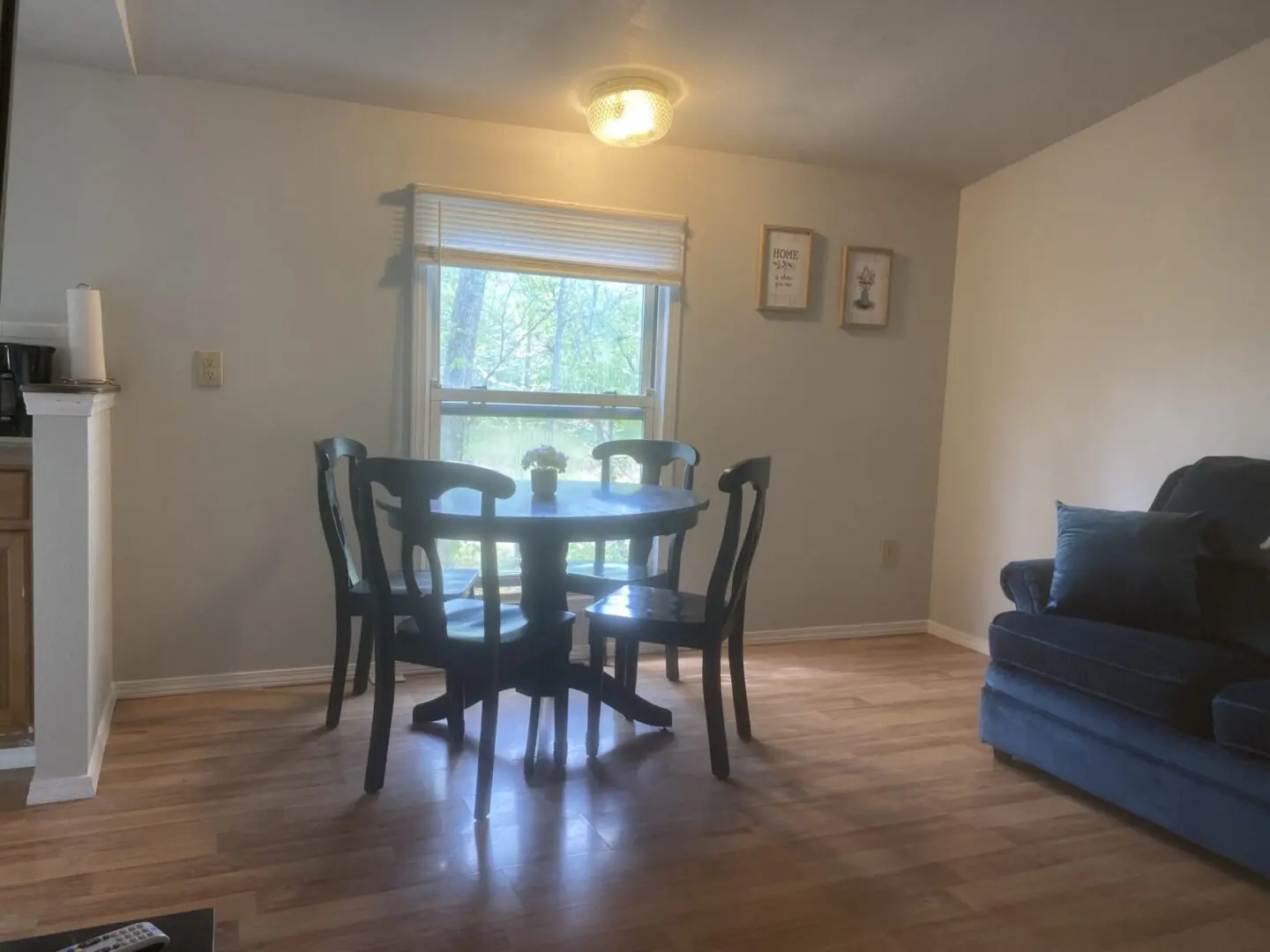 A dining room table and chairs in the middle of a living room.