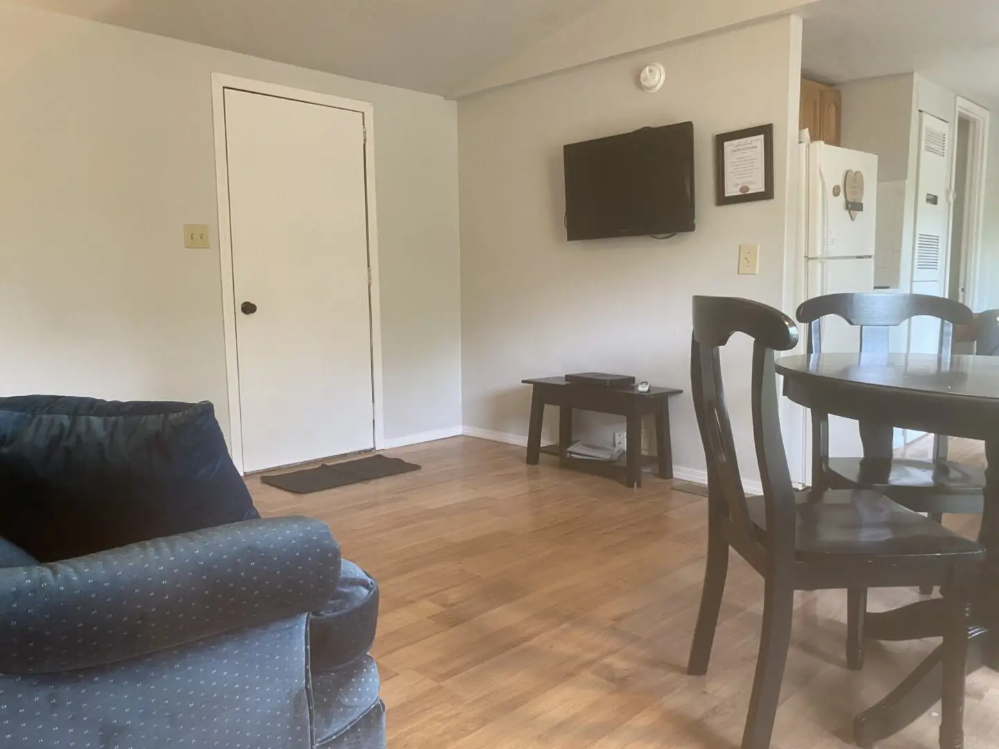 A living room with a couch, chair and television.