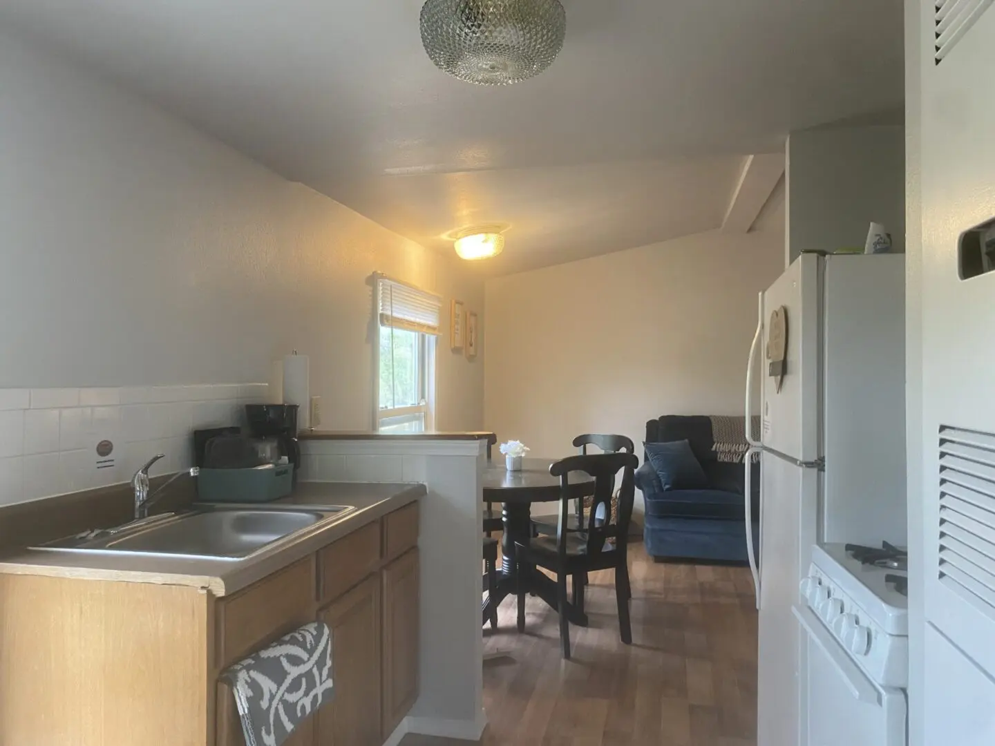 A kitchen with a sink, microwave and refrigerator.