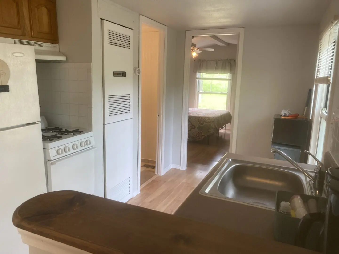 A kitchen with a sink, oven and bathtub.