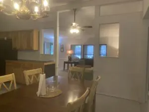 A dining room table with chairs and a mirror.