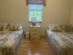A bedroom with two beds and a dresser in it