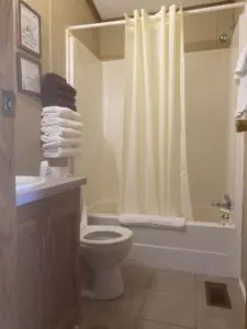 A bathroom with towels on the wall and a toilet