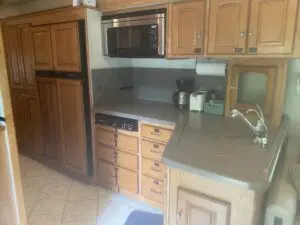 A kitchen with wooden cabinets and a microwave.