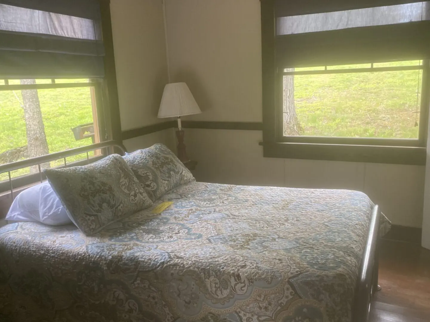 A bed room with a large bed and two windows