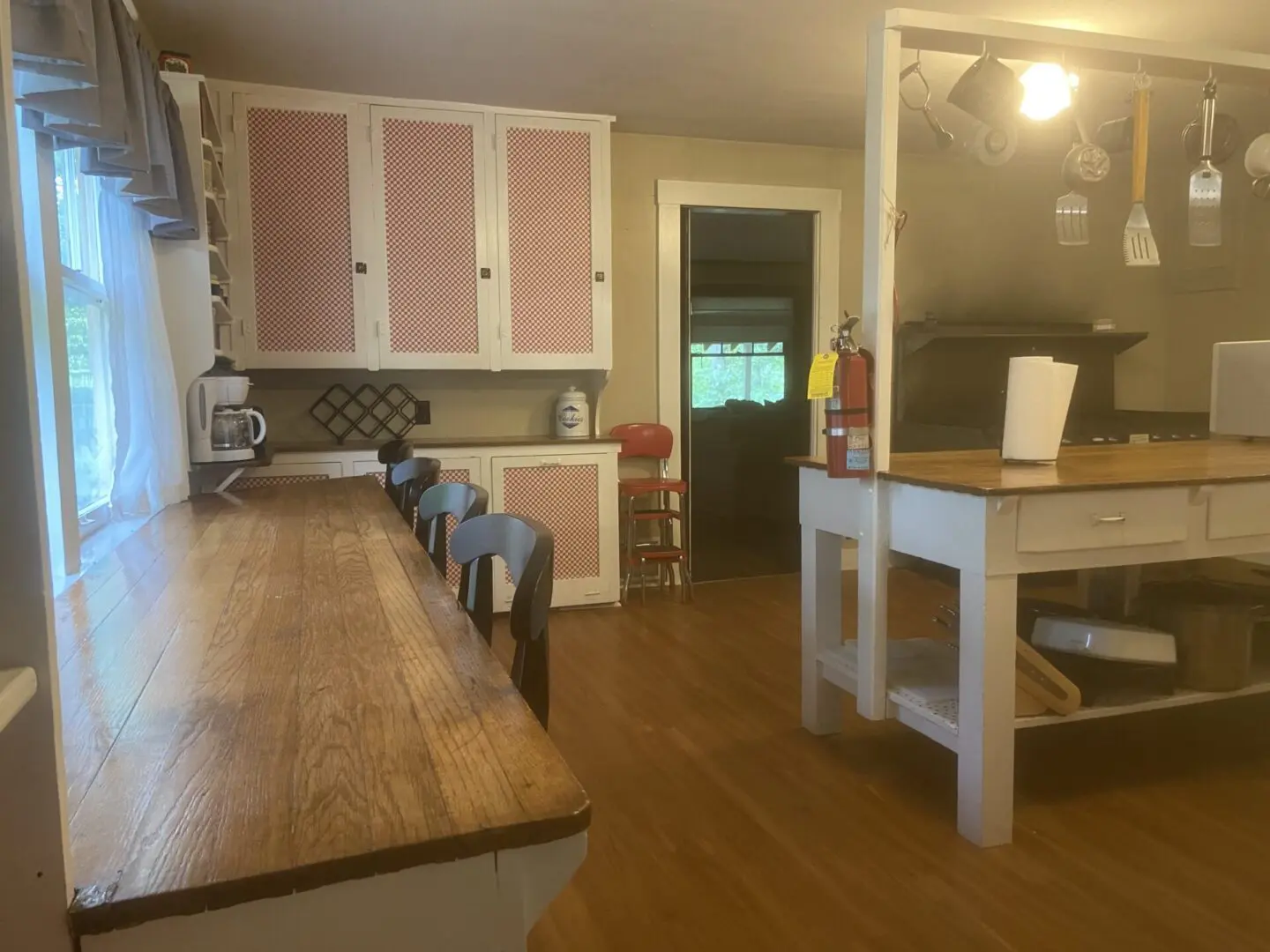 A kitchen with wooden floors and pink cabinets.