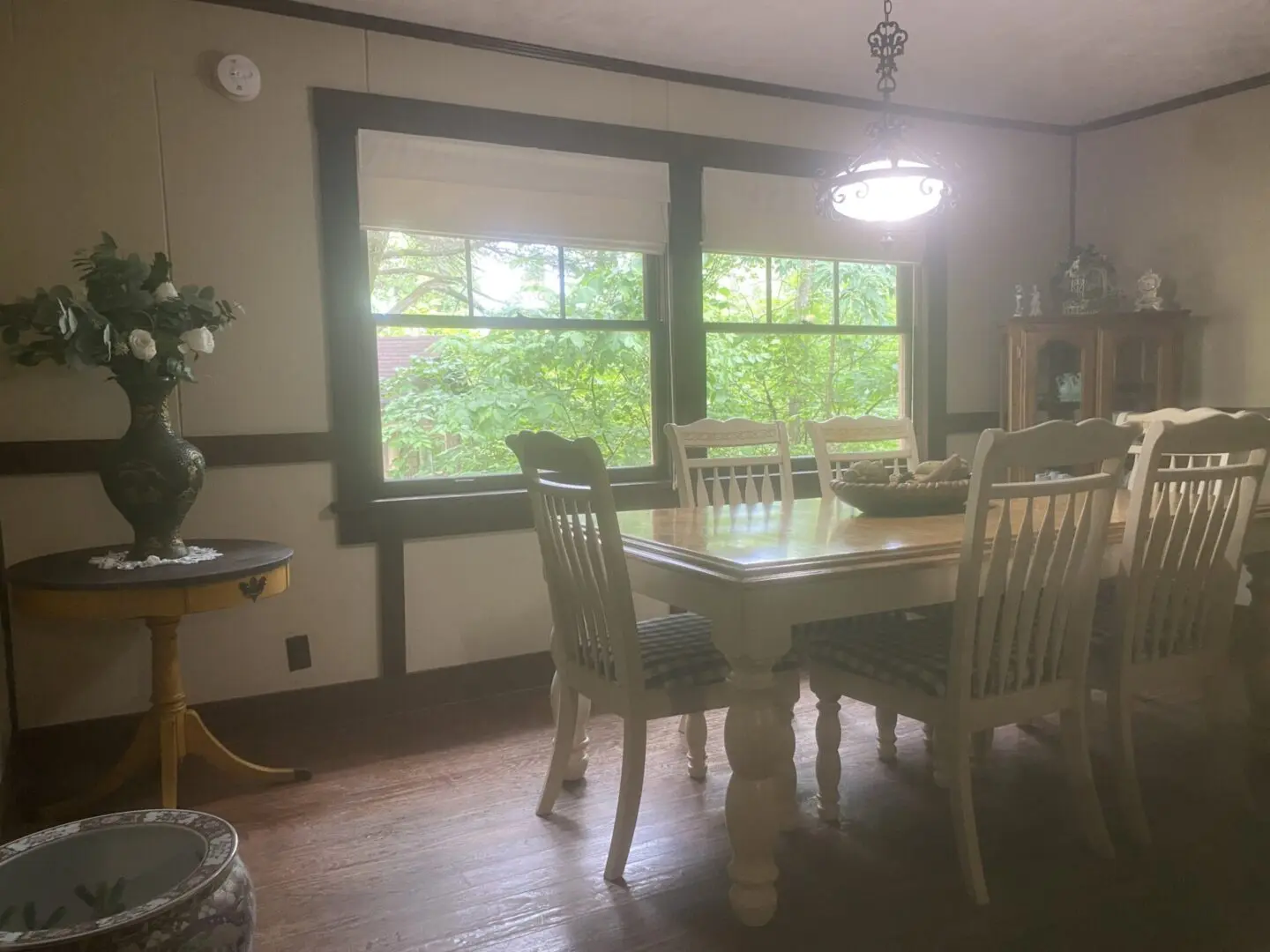 A dining room table with chairs and a plant.