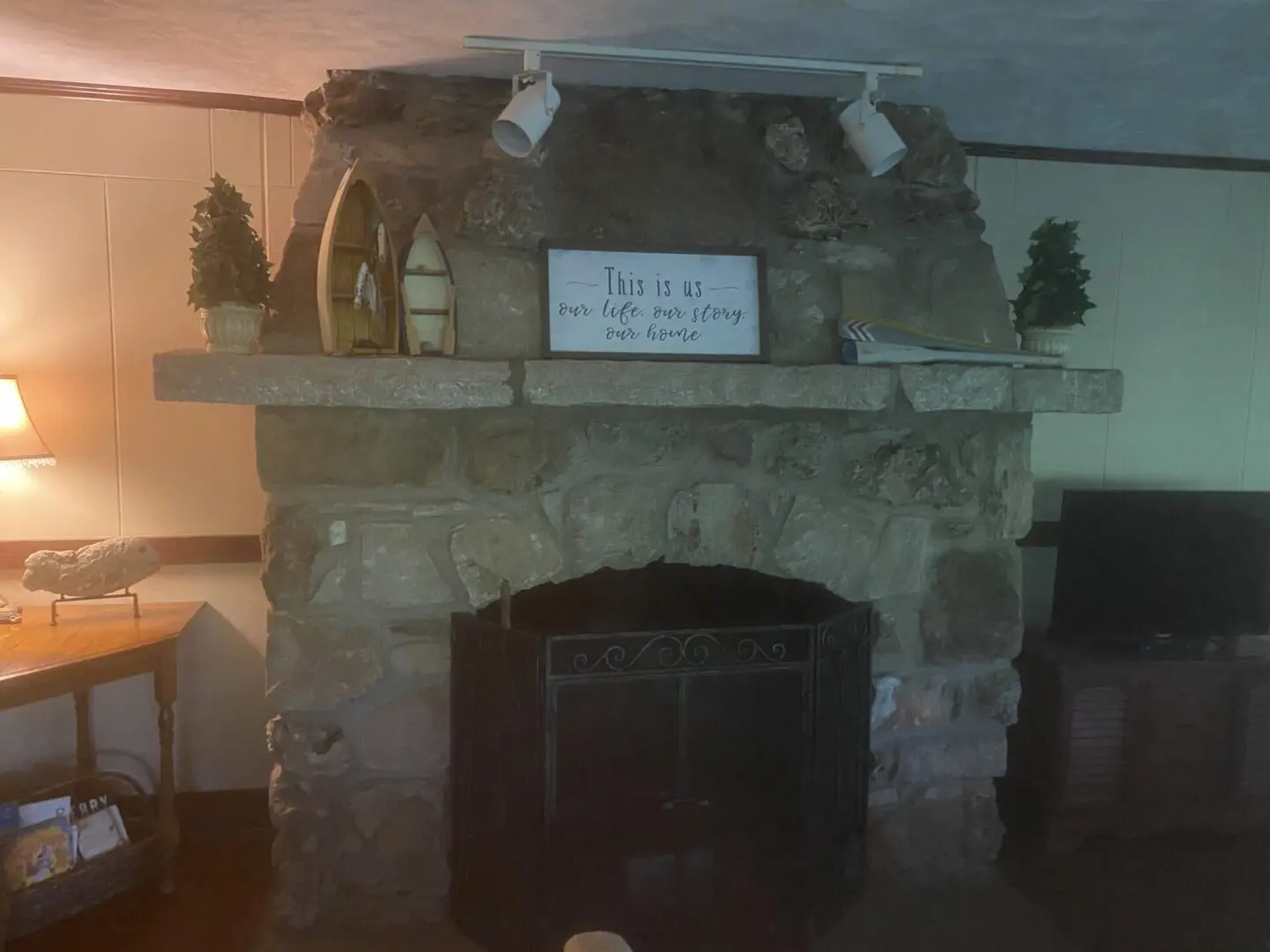 A fireplace with a sign on it's mantle.