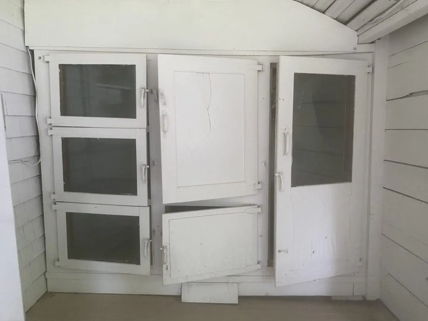 A white cabinet with glass doors and two drawers.