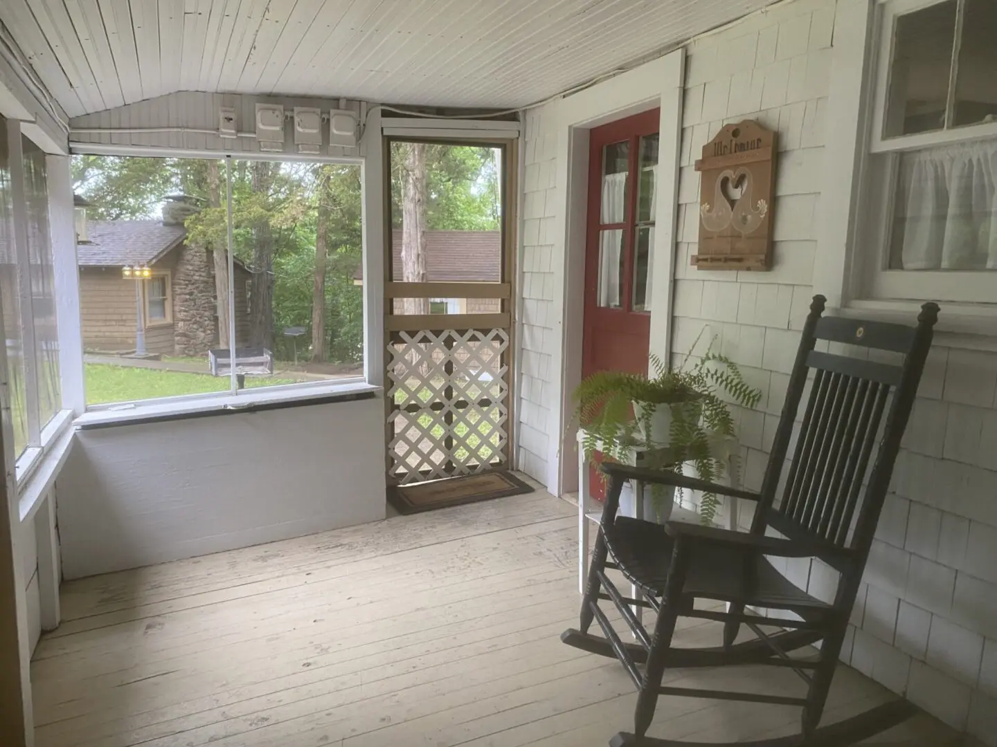 A porch with a rocking chair and a table.