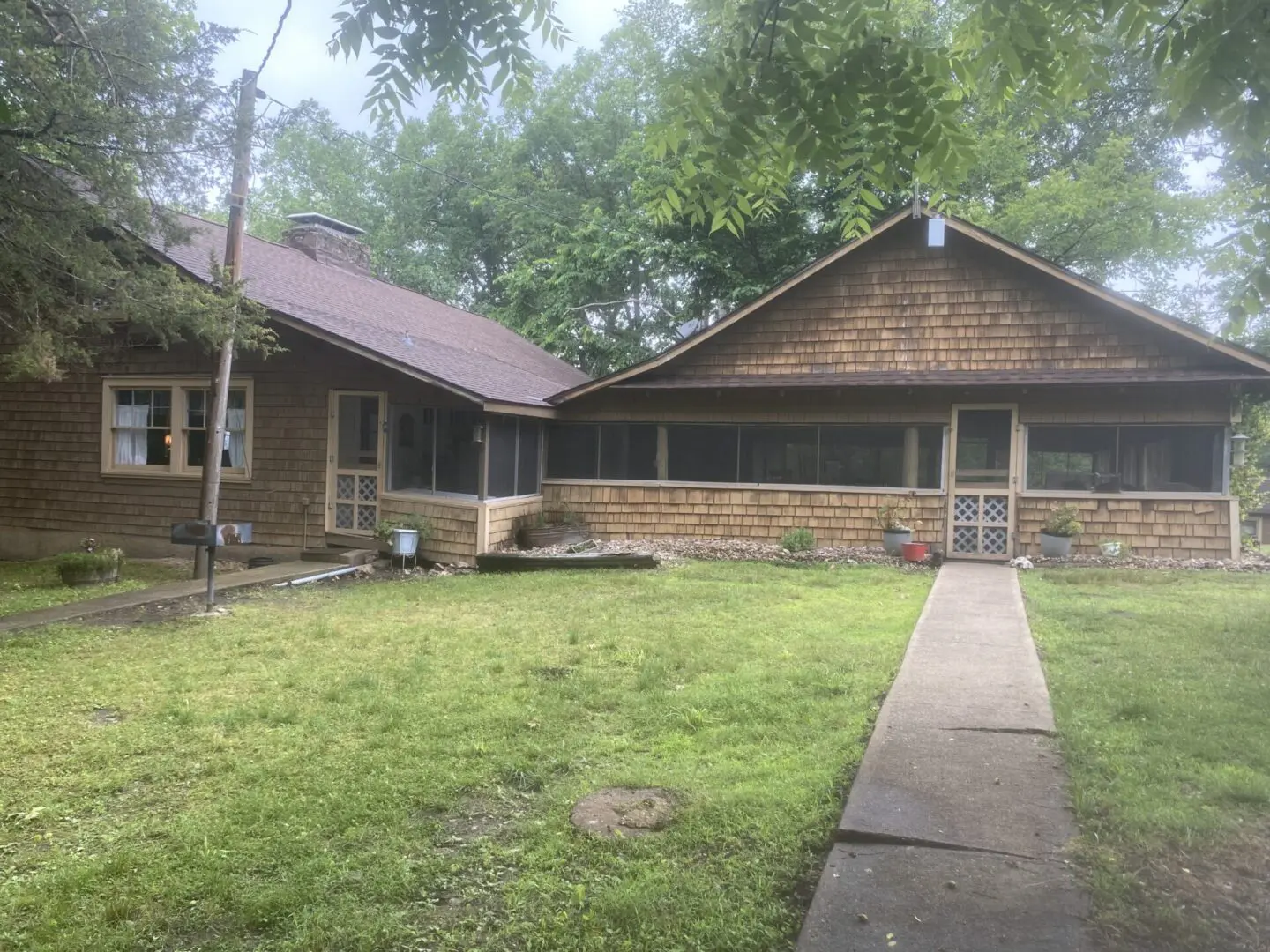 A large brown house with a porch and walkway.