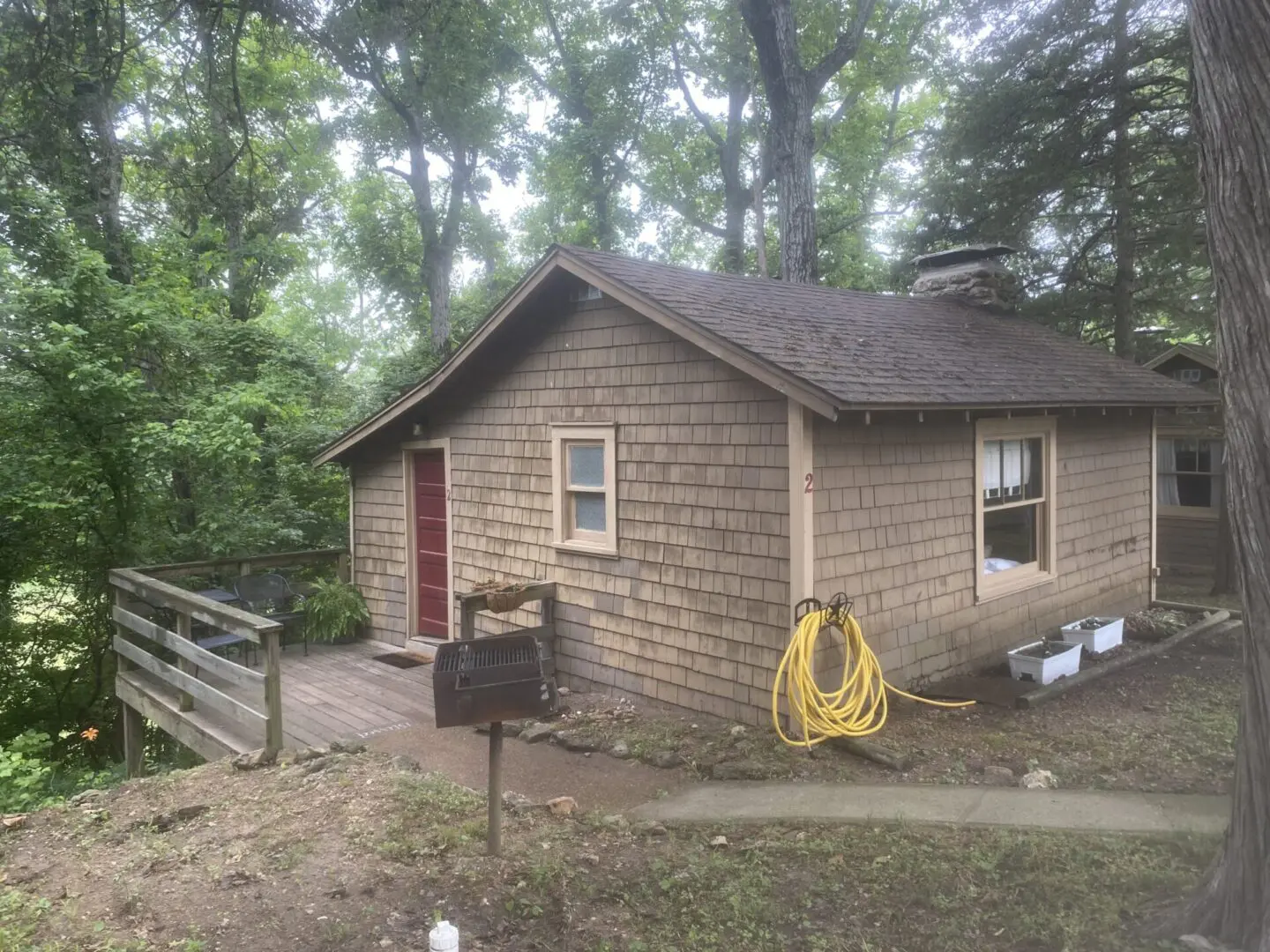 A small house with a yellow hose attached to it.