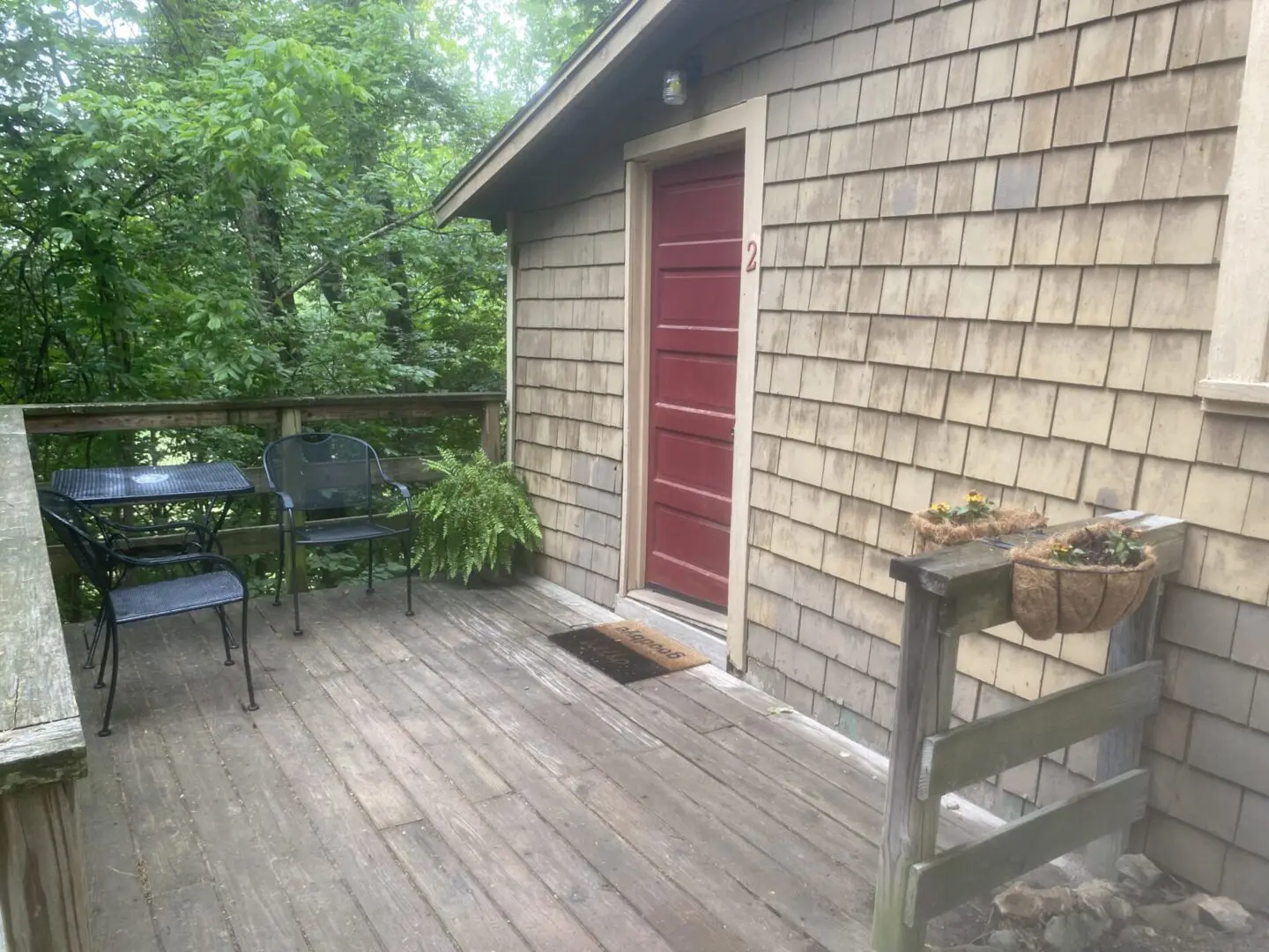 A porch with a table and chairs on it