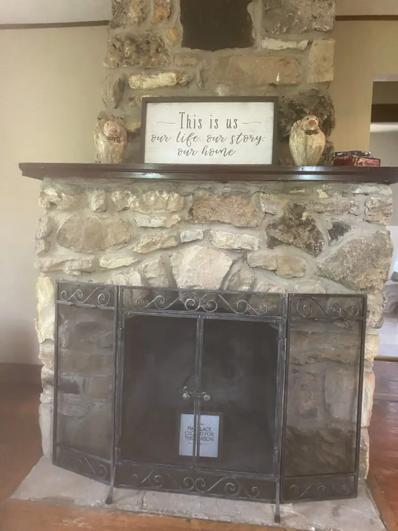 A fireplace with a sign above it that says " this is us ".