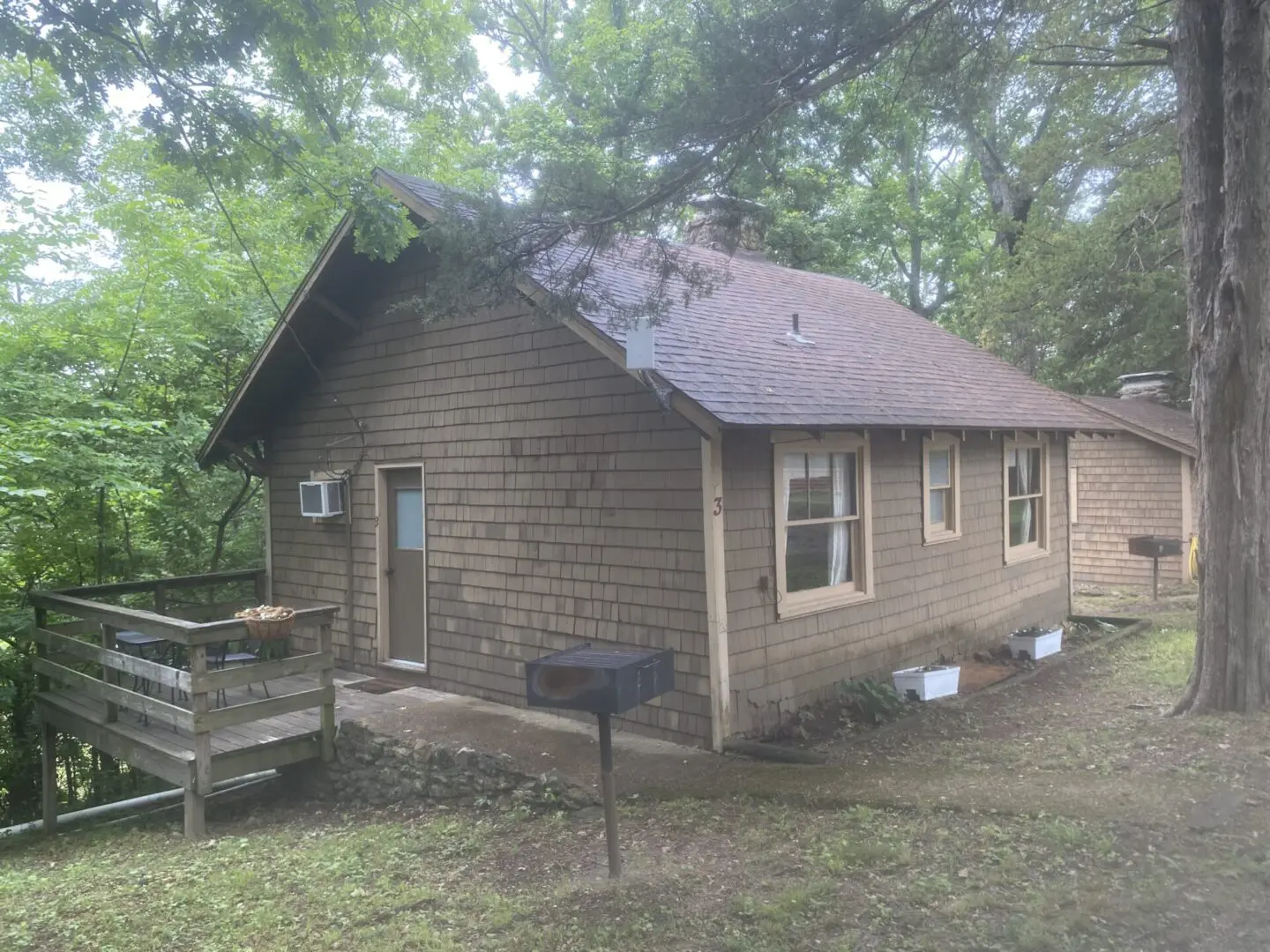 A small house with a grill in front of it.