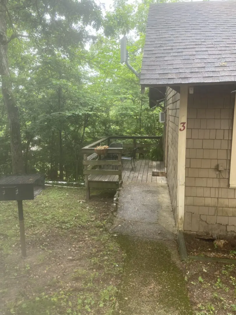 A small house with a grill in the yard.