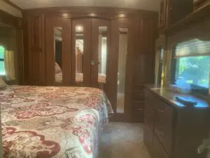 A bedroom with a large bed and wooden cabinets.