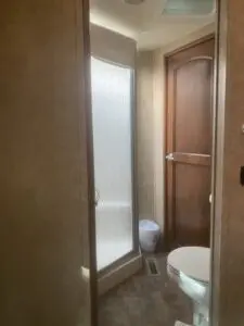A bathroom with a toilet and shower stall.