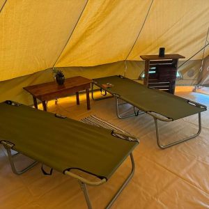 two beds and a table in a tent