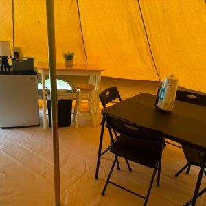 Inside a cozy tent with furniture setup.