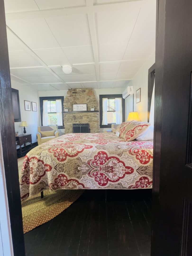 Cozy bedroom with fireplace and patterned bedding.