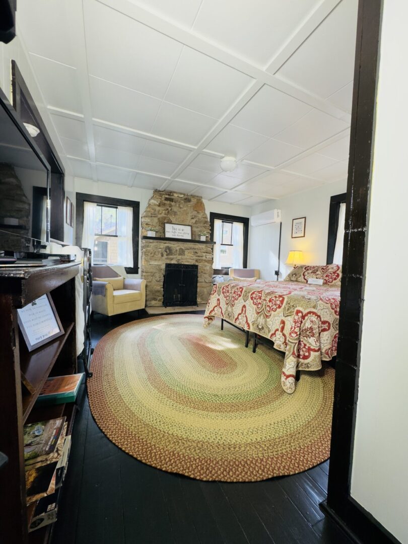 Cozy bedroom with fireplace and patterned bedspread.
