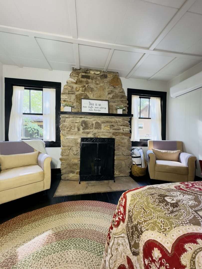 Cozy room with stone fireplace and chairs.