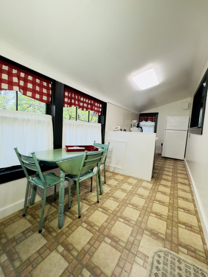 Cozy kitchen with table and checkered curtains.