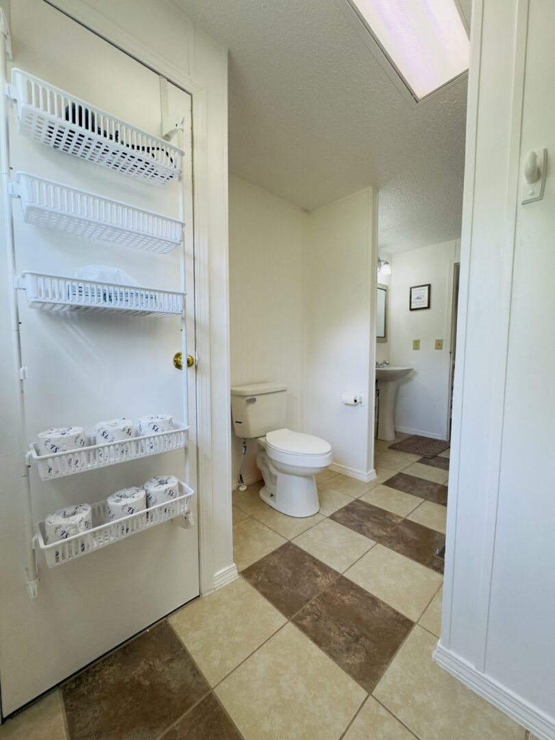 Bathroom with shelves and toilet paper rolls.