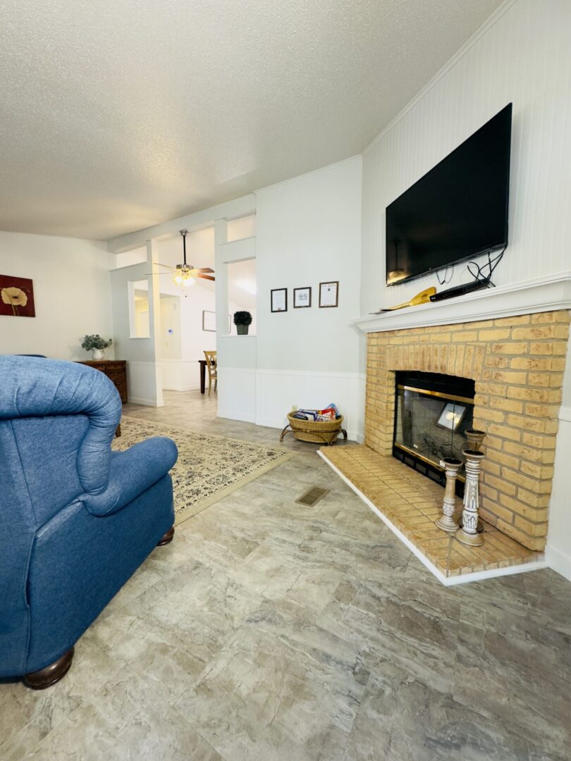 Living room with fireplace and blue chair.