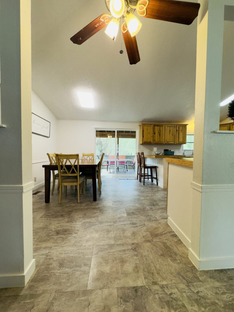 Open-plan dining and kitchen area with fan.