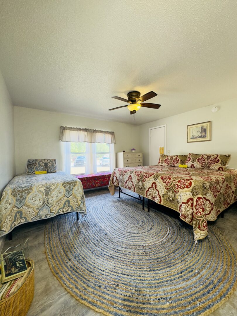 Bedroom with two beds and ceiling fan.