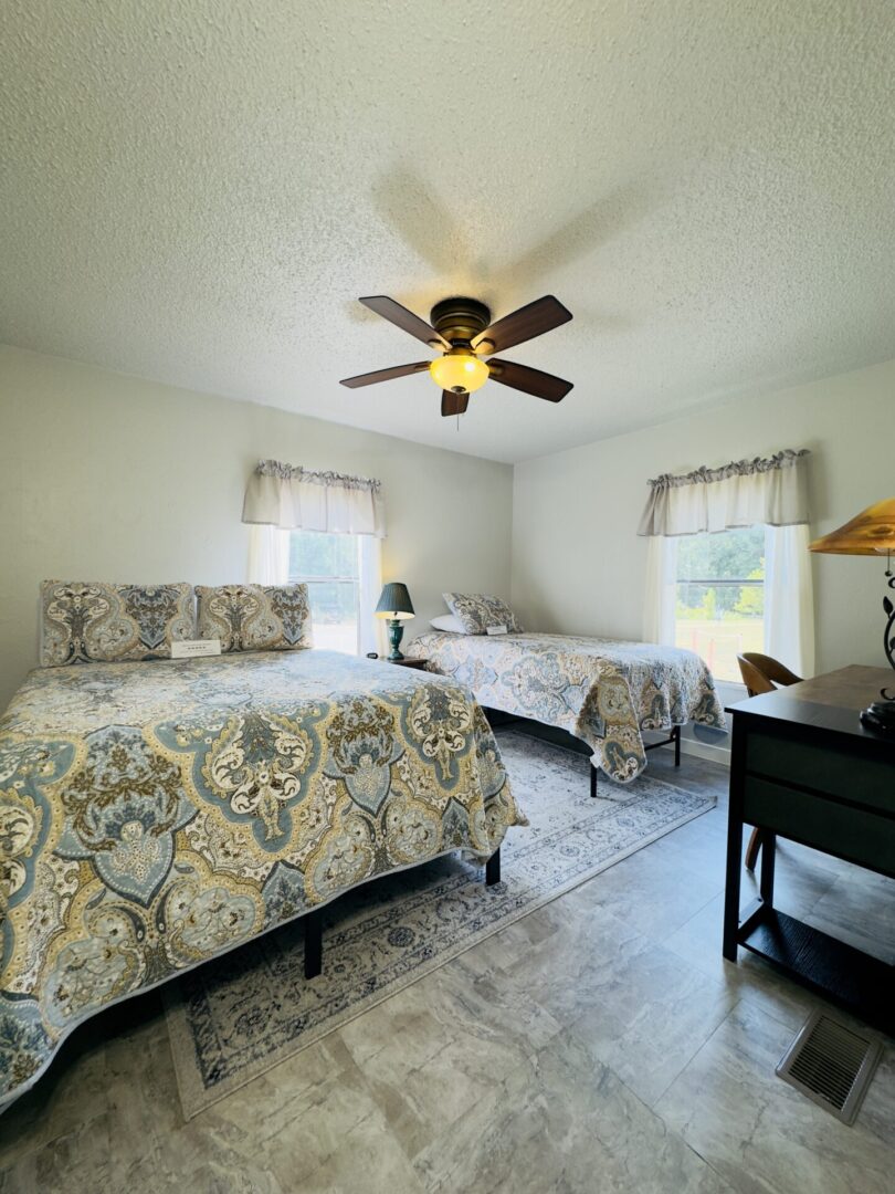 Bedroom with two beds and ceiling fan.